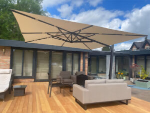 a patio with a large Bambrella Maestro parasol and chairs